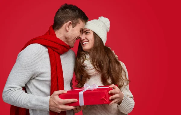 Casal com presente de Natal embrulhado mostrando carinho — Fotografia de Stock