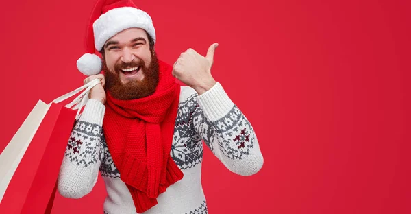 Cara alegre apontando para o lado durante as compras de Natal — Fotografia de Stock