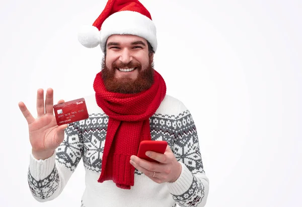 Χαρούμενος άντρας σε χριστουγεννιάτικο καπέλο με πιστωτική κάρτα και smartphone — Φωτογραφία Αρχείου