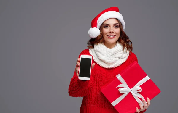 Mosolygós nő karácsonyi ajándék bemutató smartphone — Stock Fotó
