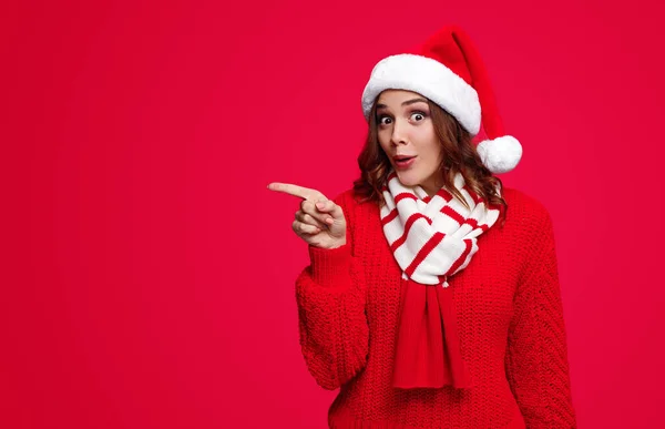 Sorpresa donna in cappello Babbo Natale indicando da parte — Foto Stock