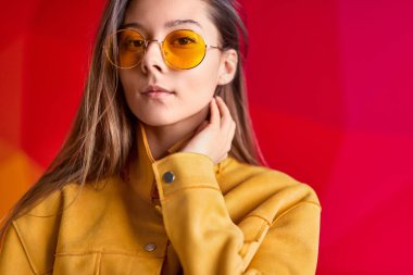 Sakin kadın parlak ceketle boynuna dokunuyor.