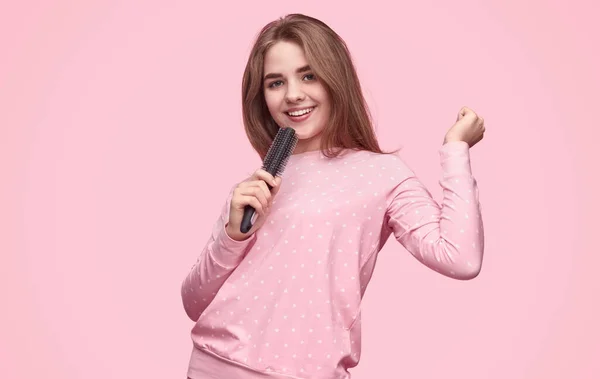 Adolescente sorrindo cantando em escova de cabelo — Fotografia de Stock