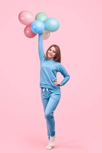 Renkli balonlar taşıyan pijamalı neşeli genç kız. — Stok fotoğraf