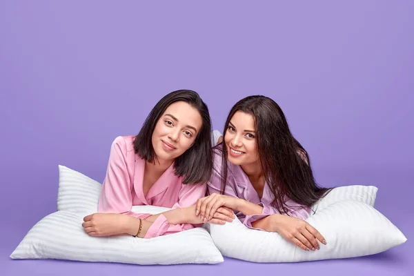 Jonge vrouwen liggend op kussens — Stockfoto