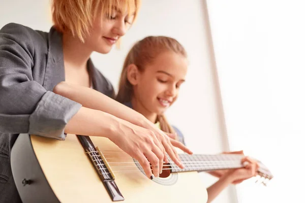 Donna insegnare ragazza a suonare la chitarra — Foto Stock