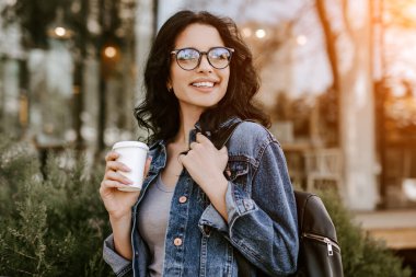 Neşeli kahve aşığı sokakta yürüyor