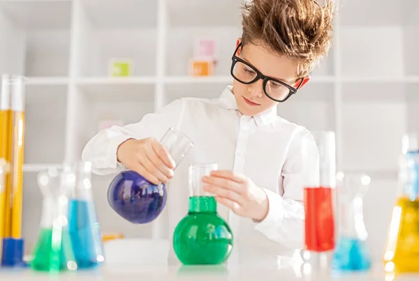 Mądry chłopiec przeprowadzający eksperyment z płynami — Zdjęcie stockowe