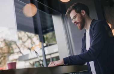 Masada dizüstü bilgisayarda çalışan ilham verici bir adam.