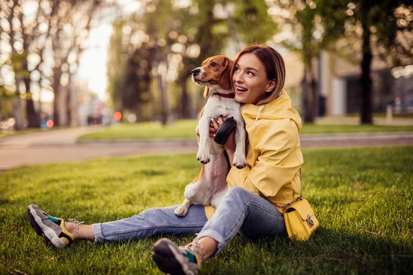 Woman and dog bonding in grass in park — Stock Photo, Image