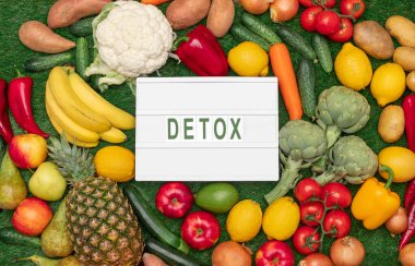 Tahtanın etrafına işlenmiş çiğ meyve ve sebzeler.