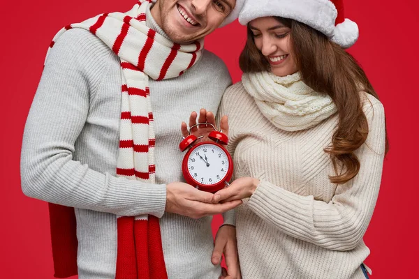 알람 시계를 들고 있는 산타 모자를 쓴 부부 — 스톡 사진