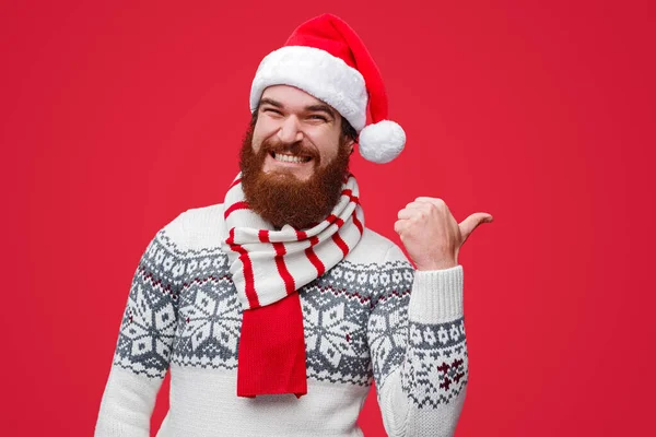 Feliz macho em Santa chapéu apontando para longe — Fotografia de Stock