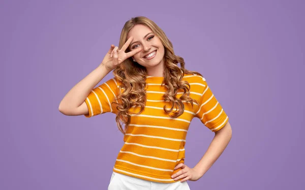 Cheerful woman showing V sign and smiling — Stock Photo, Image