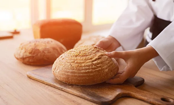 Piekarz roślin uprawnych umieszczenie chleba na pokładzie — Zdjęcie stockowe