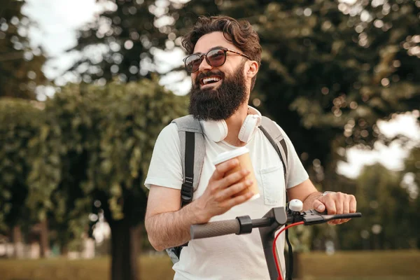 Hipster feliz con scooter de montar bebida —  Fotos de Stock
