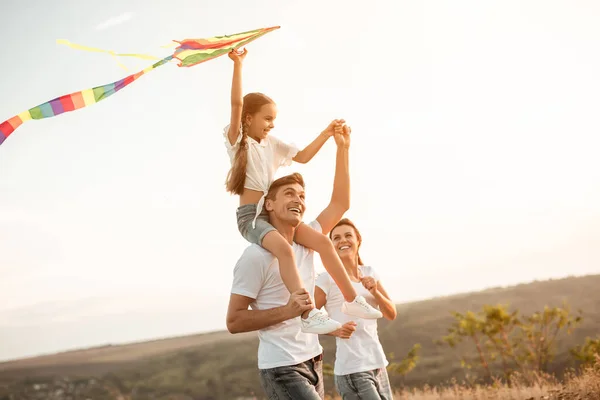 Szczęśliwa rodzina bawi się z latawcem w przyrodzie — Zdjęcie stockowe
