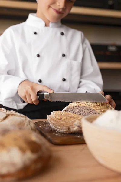 Panadero de cosechas cortando pan fresco — Foto de Stock