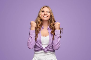 Neşeli kadın başarıyı kutluyor ve yukarı bakıyor.