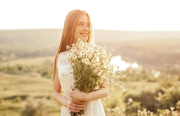 Cheerful teenager with bunch of chamomiles in nature — Stock Photo, Image