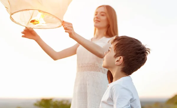 Jongen op zoek naar zus lanceren hemel lantaarn — Stockfoto