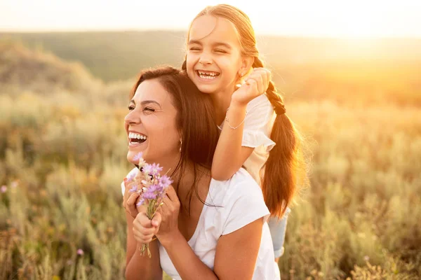 Gelukkige moeder en dochter rustend op het zomerveld — Stockfoto