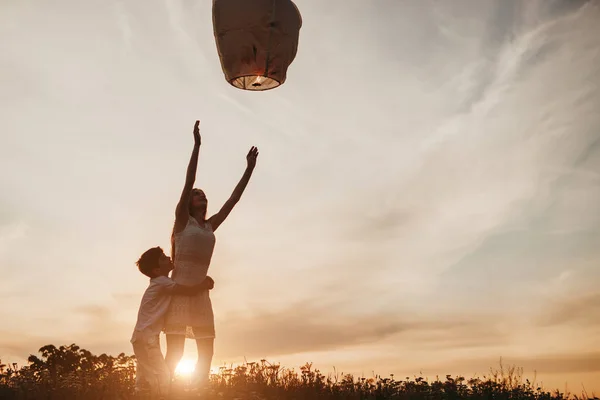 Hermanos lanzando la linterna del cielo durante el atardecer — Foto de Stock