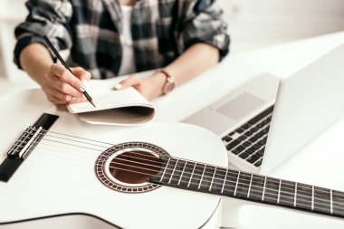Ekin kadın internette gitar çalmayı öğreniyor.
