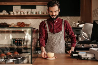 Kahveyi tezgaha koyan erkek barista.