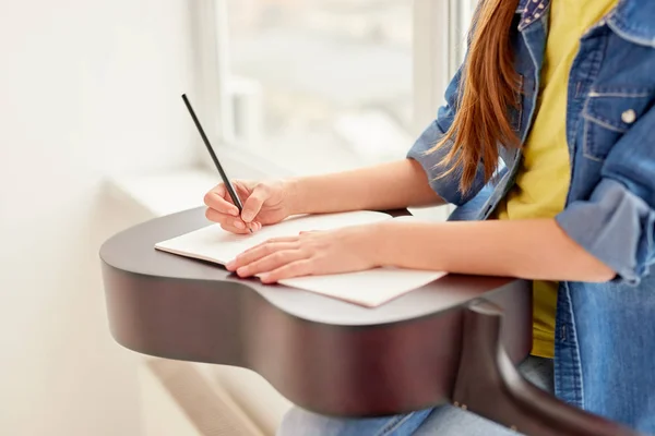 Crop girl prendere appunti durante la lezione di chitarra — Foto Stock