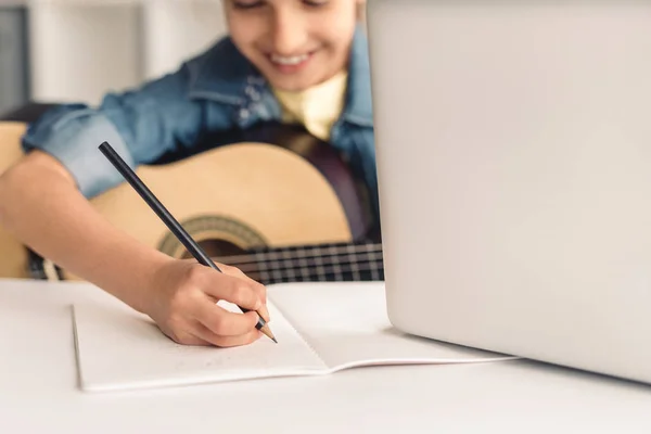 Criança fazendo anotações durante a aula de música online — Fotografia de Stock