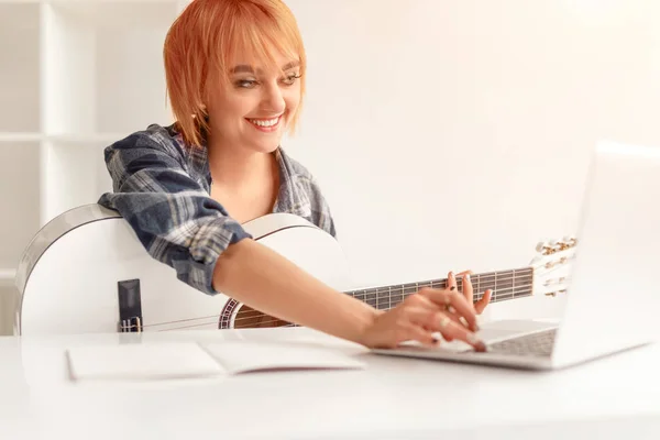 Veselý žena prohlížení online kytarové lekce — Stock fotografie