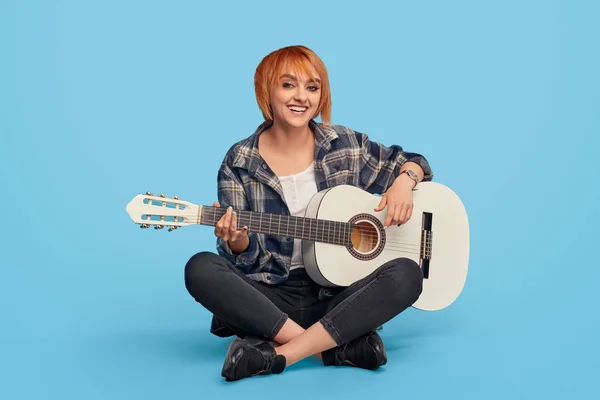 Donna eccitata sorridente suonare la chitarra — Foto Stock