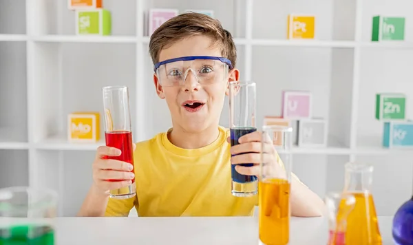 Astonished little chemist studying at school