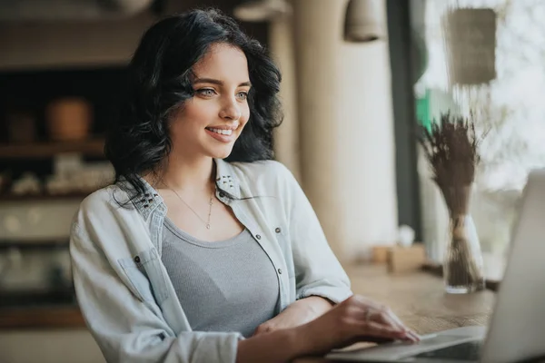 Inspired woman browsing laptop while resting in cafe — Stock Photo, Image