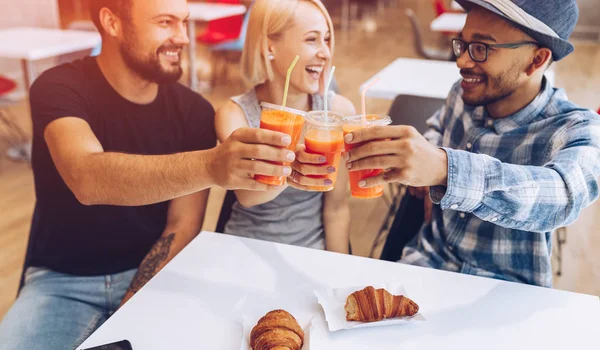 Happy diverse friends clinking cups in cafe — ストック写真