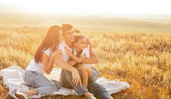 Happy family hugging and resting in nature — Stock Photo, Image
