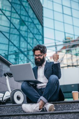 Başarılı olan dizüstü bilgisayarlı mutlu yönetici