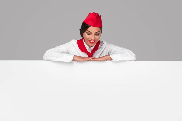 Glückliche Stewardess blickt auf Werbeplakat — Stockfoto