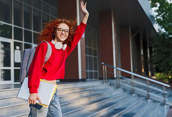 Щасливий червоний волохатий студент виходить з університету — стокове фото