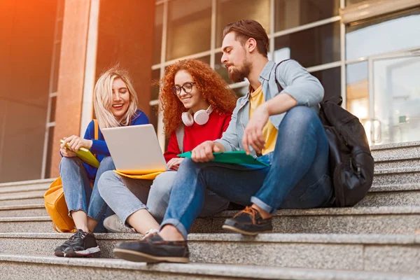 Vriendengroep met laptop buiten de universiteit — Stockfoto