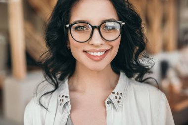 Şık bir bayan sokakta kameraya bakıyor.