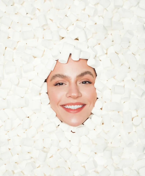 Glimlachende vrouw temidden van witte marshmallows — Stockfoto