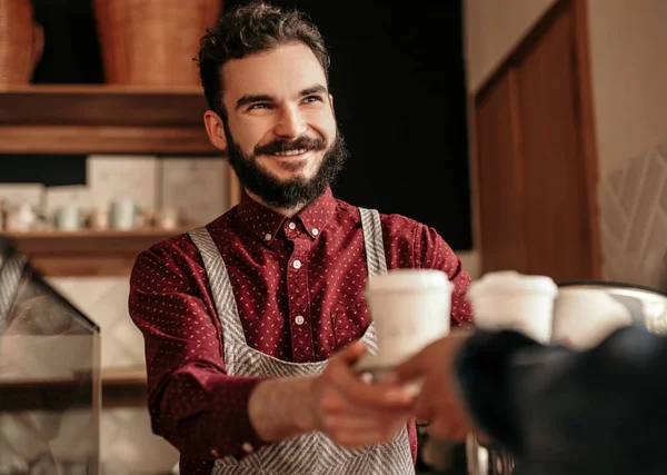 Camarero amistoso vendiendo café a cliente sin rostro — Foto de Stock