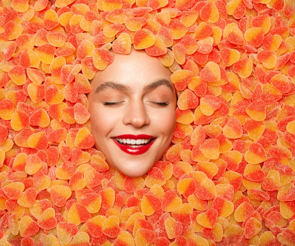 Delighted female resting in fruit jelly candies Stock Image