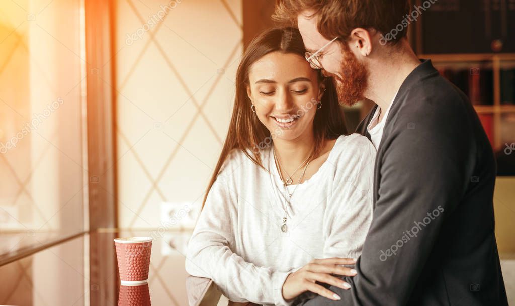 Young couple hugging in cafe