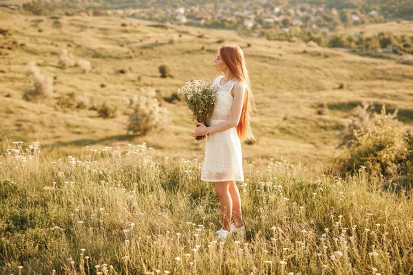 Adolescente com flores descansando no campo — Fotografia de Stock