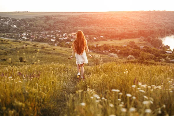 Unrecognizable young female running in field in evening — Stock Photo, Image