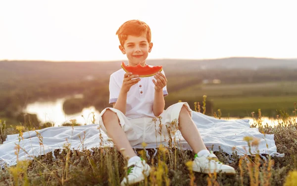 Menino comendo melancia na natureza — Fotografia de Stock