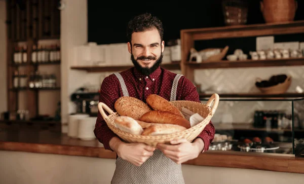 Panadero alegre con cesta llena de pan — Foto de Stock